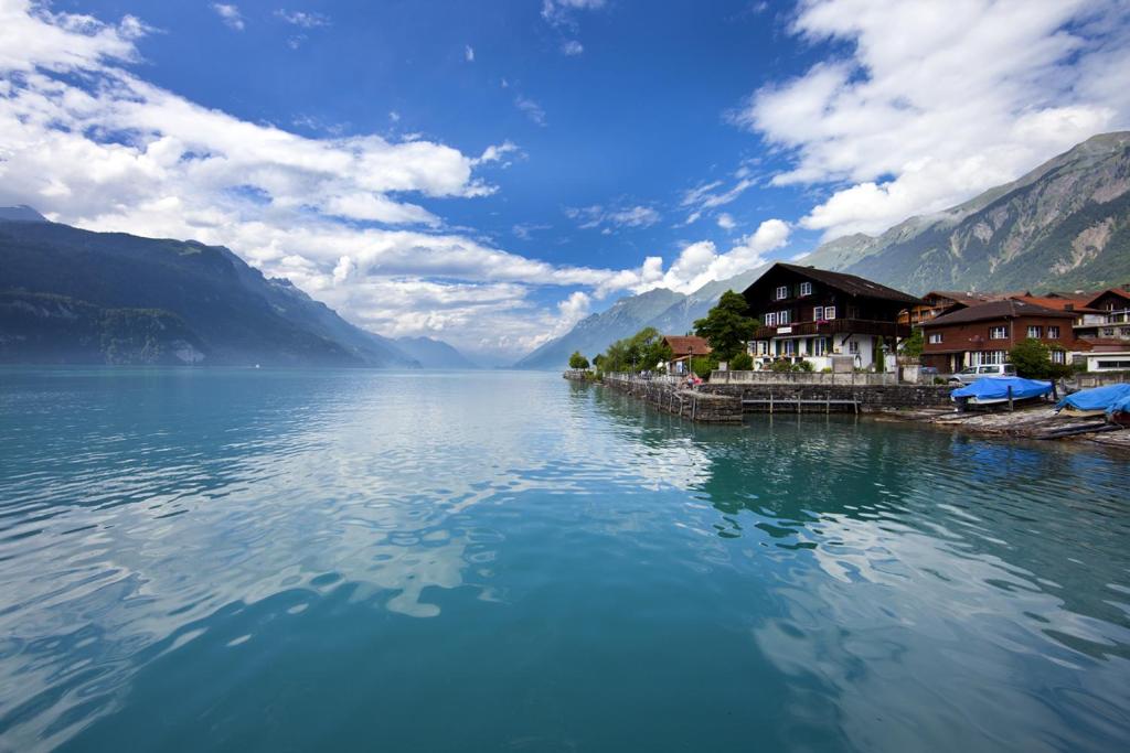 a large body of water with houses and mountains at CHALET ROMANTICA Carpe Diem BEST VIEW BEST LOCATION in Brienz