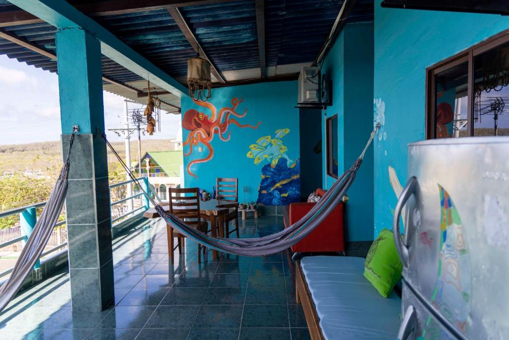 a room with a hammock and a table and chairs at Mango Tree in San Cristobal