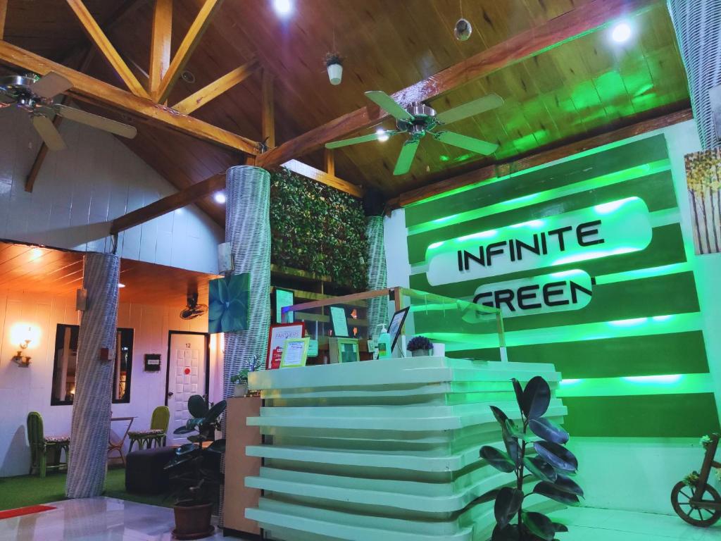 a store with a green and white sign and plants at Infinite Green Pension in Puerto Princesa City