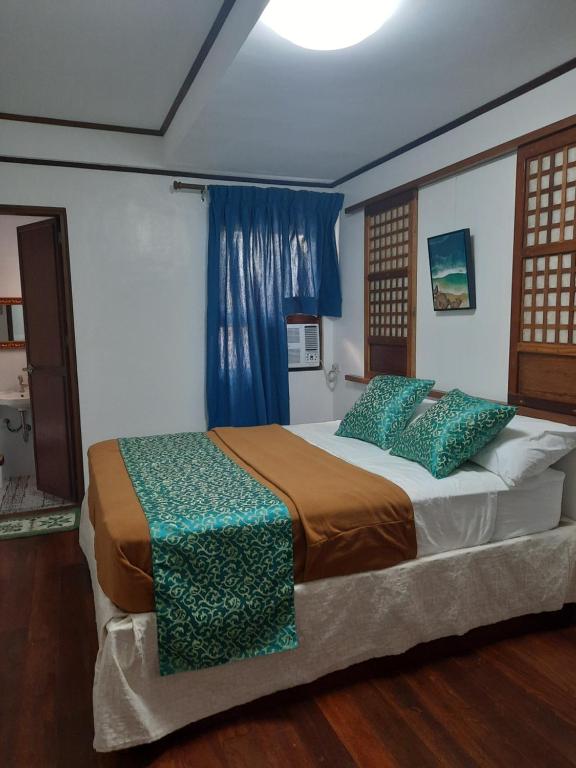 a bedroom with a large bed with a blue curtain at BALÉ in Malabañas