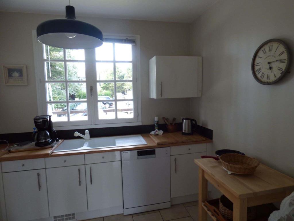 a kitchen with a sink and a clock on the wall at Maison Saint-Pair-sur-Mer, 5 pièces, 8 personnes - FR-1-361-56 in Saint-Pair-sur-Mer