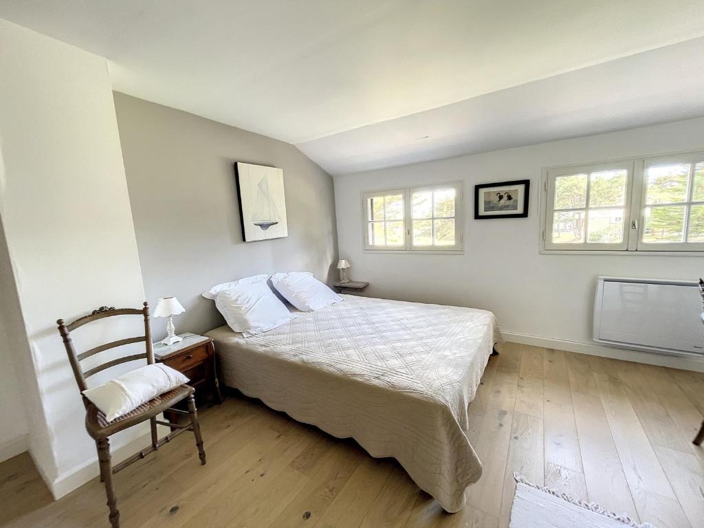 a bedroom with a bed and a chair and windows at Maison Saint-Pair-sur-Mer, 5 pièces, 8 personnes - FR-1-361-56 in Saint-Pair-sur-Mer