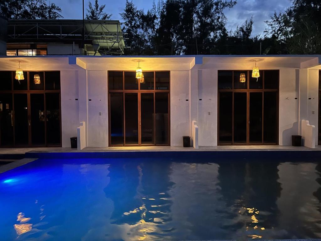 - une piscine en face d'une maison la nuit dans l'établissement LaZerena Lodge, à Zambales