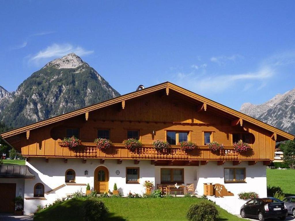 una casa con balcone con una montagna sullo sfondo di Appartement Christine a Pertisau