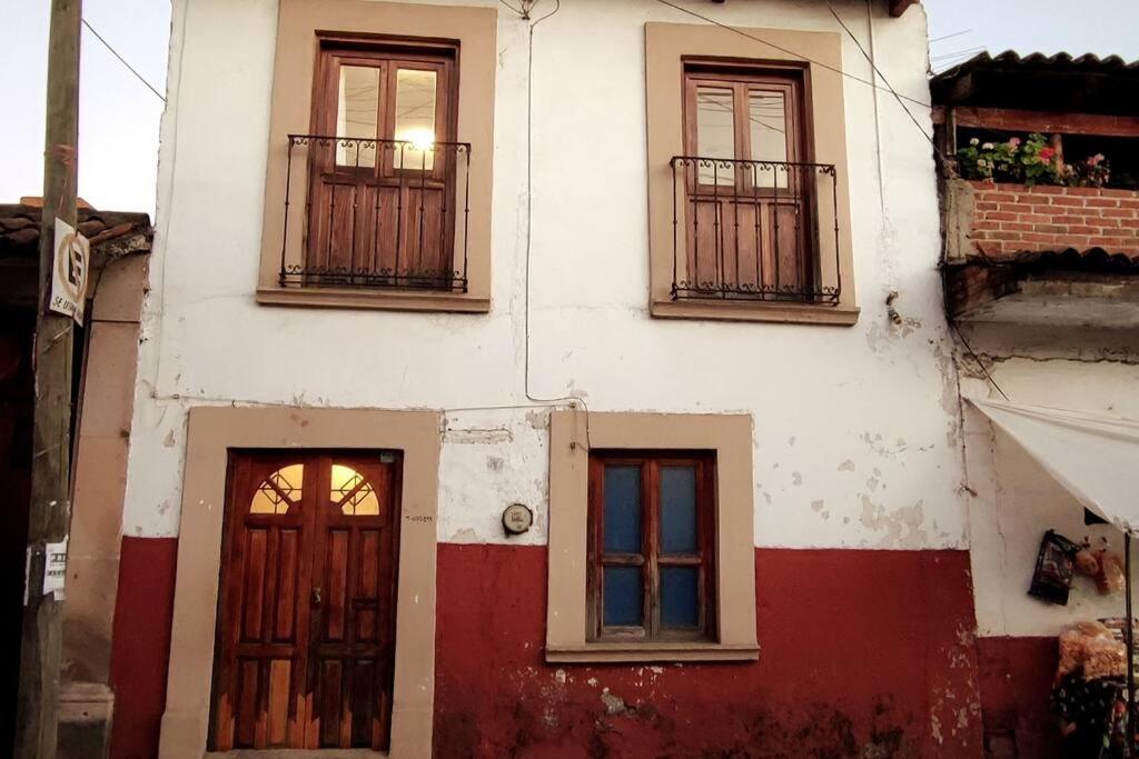 un edificio antiguo con dos puertas y ventanas en Linda casa azul ubicada en el corazón de Pátzcuaro en Pátzcuaro
