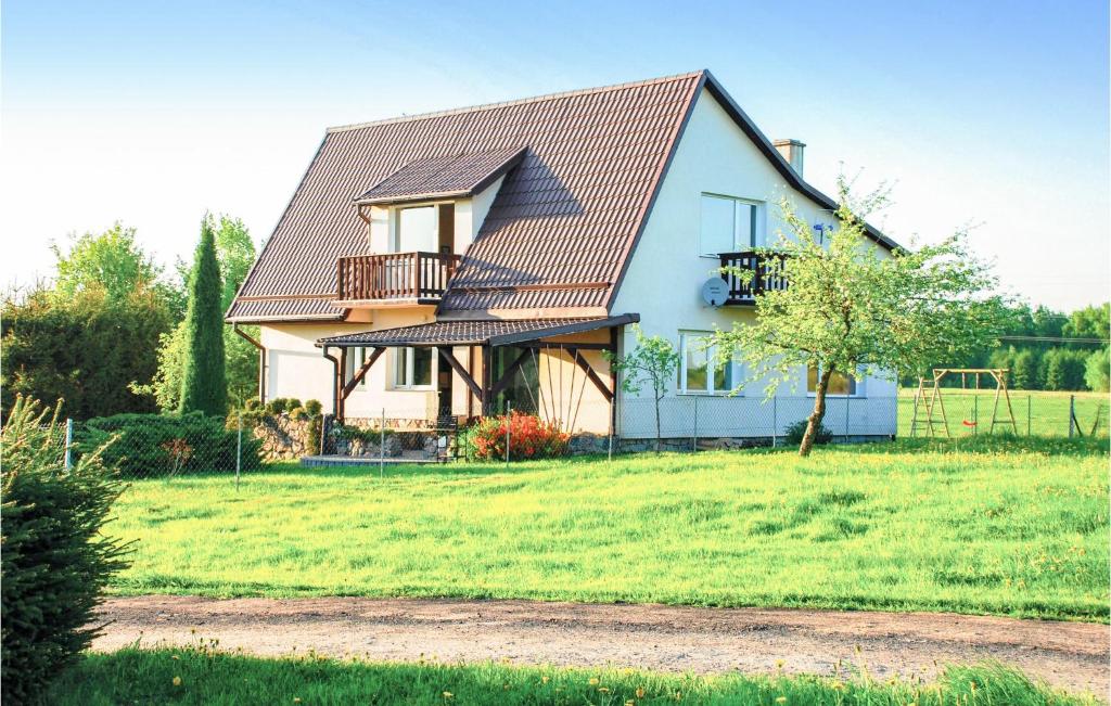 a house with a metal roof on a green field at Stunning Home In Lidzbark Warminski With House Sea View in Lidzbark Warmiński
