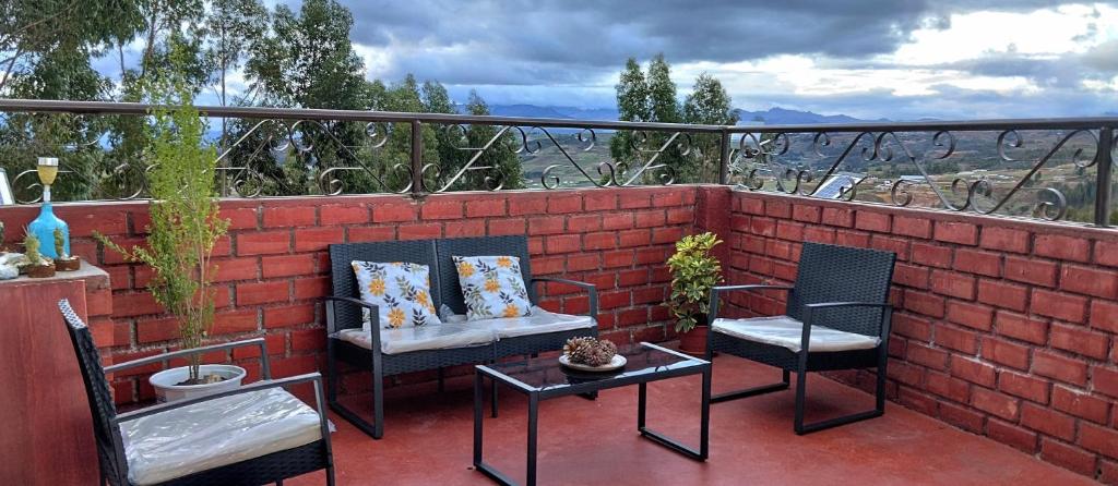 2 sillas y una mesa en un patio de ladrillo en Weninger Lodge en Urubamba
