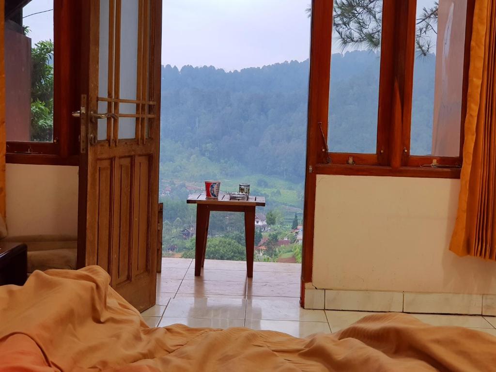 an open door to a room with a bed and a table at Argapuri Jungle Resort Ciwidey in Ciwidey
