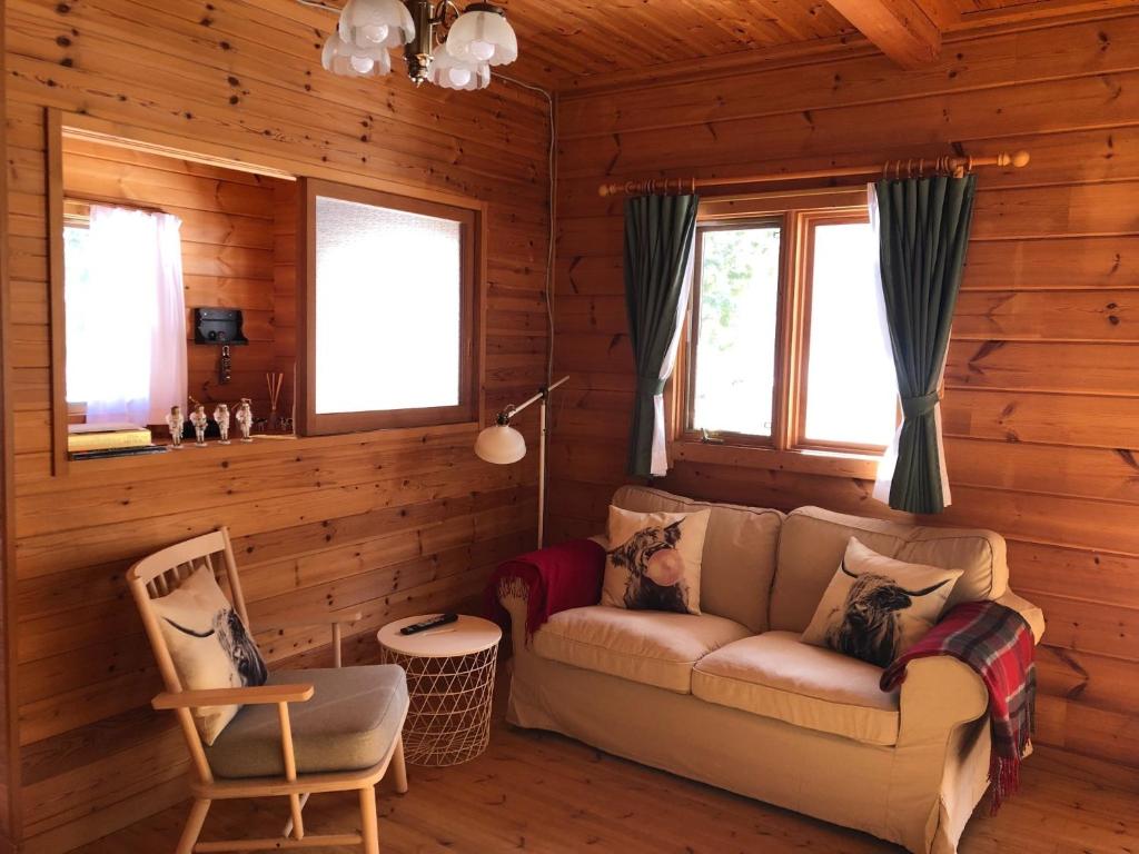 een woonkamer met een bank in een blokhut bij Swiss Chalet - Vacation STAY 11450v in Iida