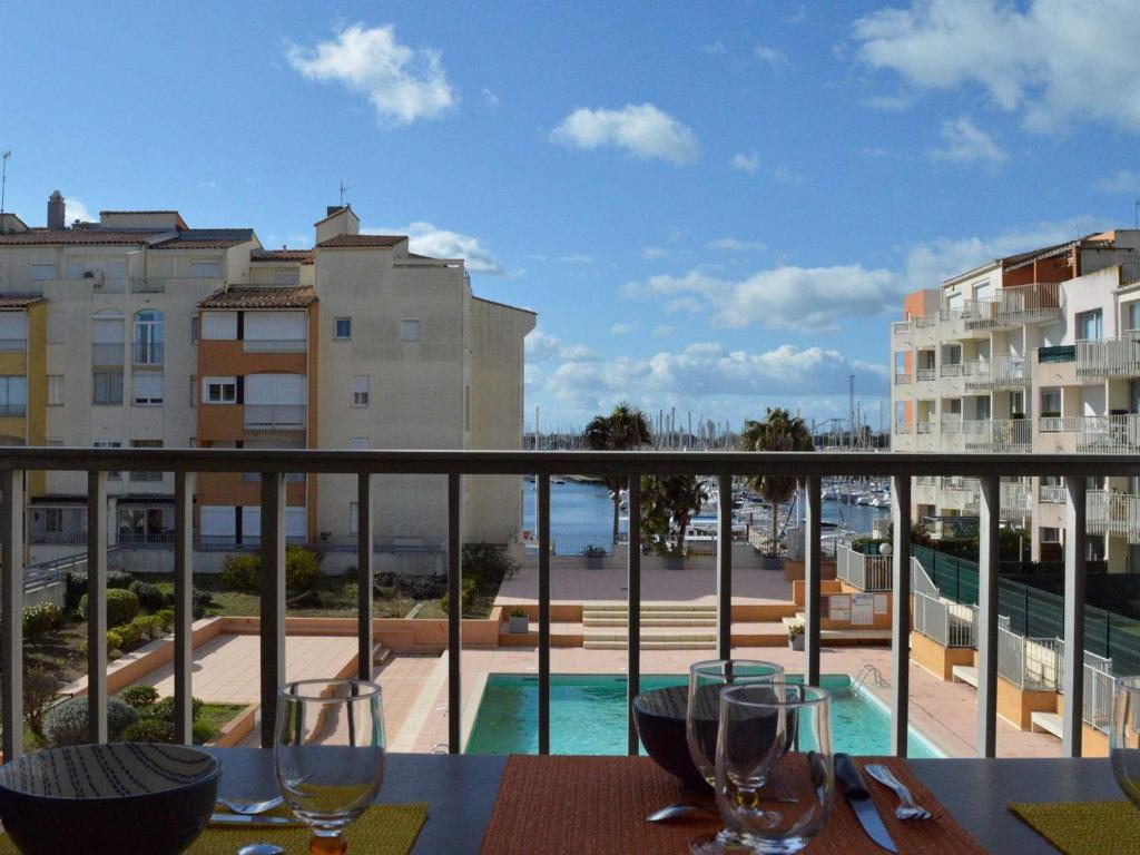 - un balcon avec une table et des verres à vin dans l'établissement Cap d'Agde: Appt 2 pièces cabine, 6 couchages, proche plage, loggia, parking - FR-1-249-127, au Cap d'Agde