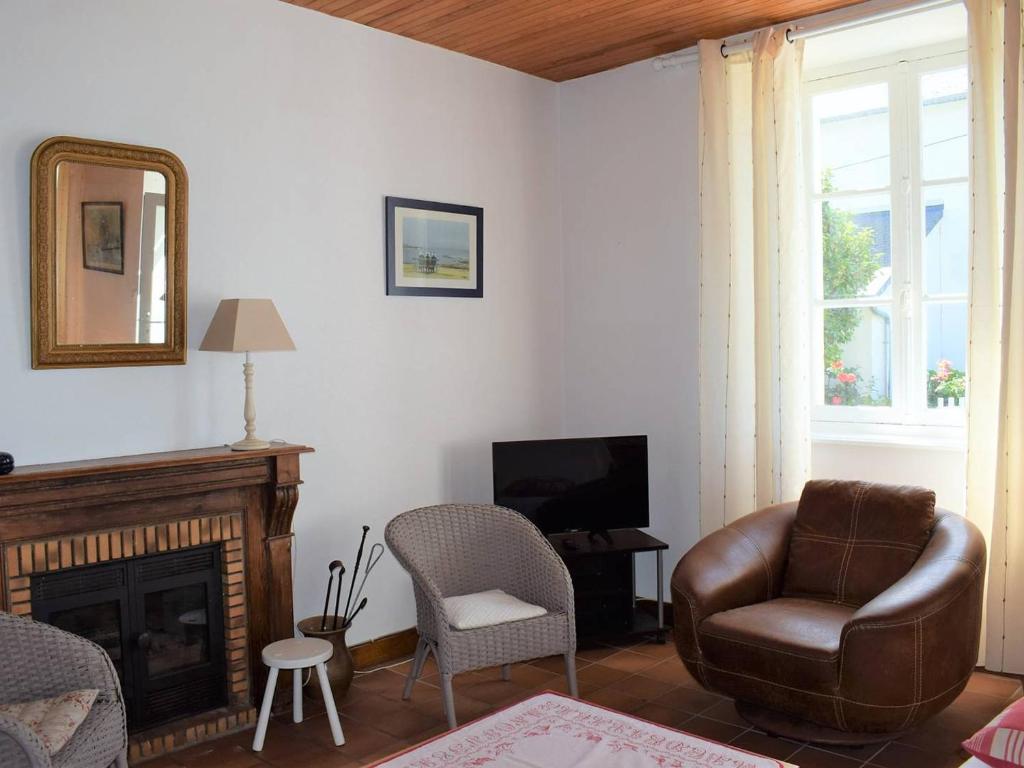 a living room with a leather chair and a television at Maison Trégastel, 4 pièces, 6 personnes - FR-1-368-106 in Trégastel