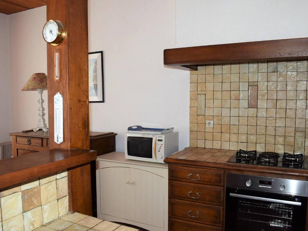 a kitchen with a stove and a microwave at Maison Trégastel, 4 pièces, 6 personnes - FR-1-368-106 in Trégastel