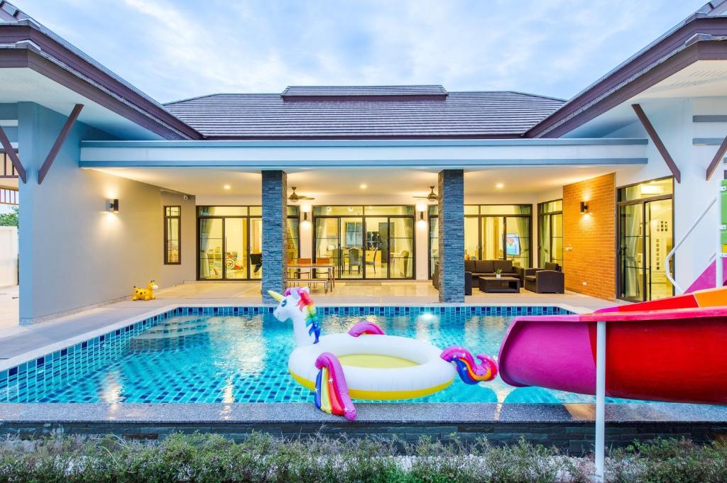 a swimming pool with a pool noodle in front of a house at Aora Pool Villa Huahin in Ban Bo Fai (1)