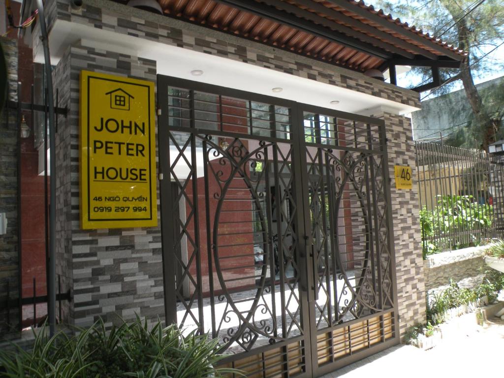een huis met een ijzeren poort met een bord erop bij John Peter House in Sầm Sơn