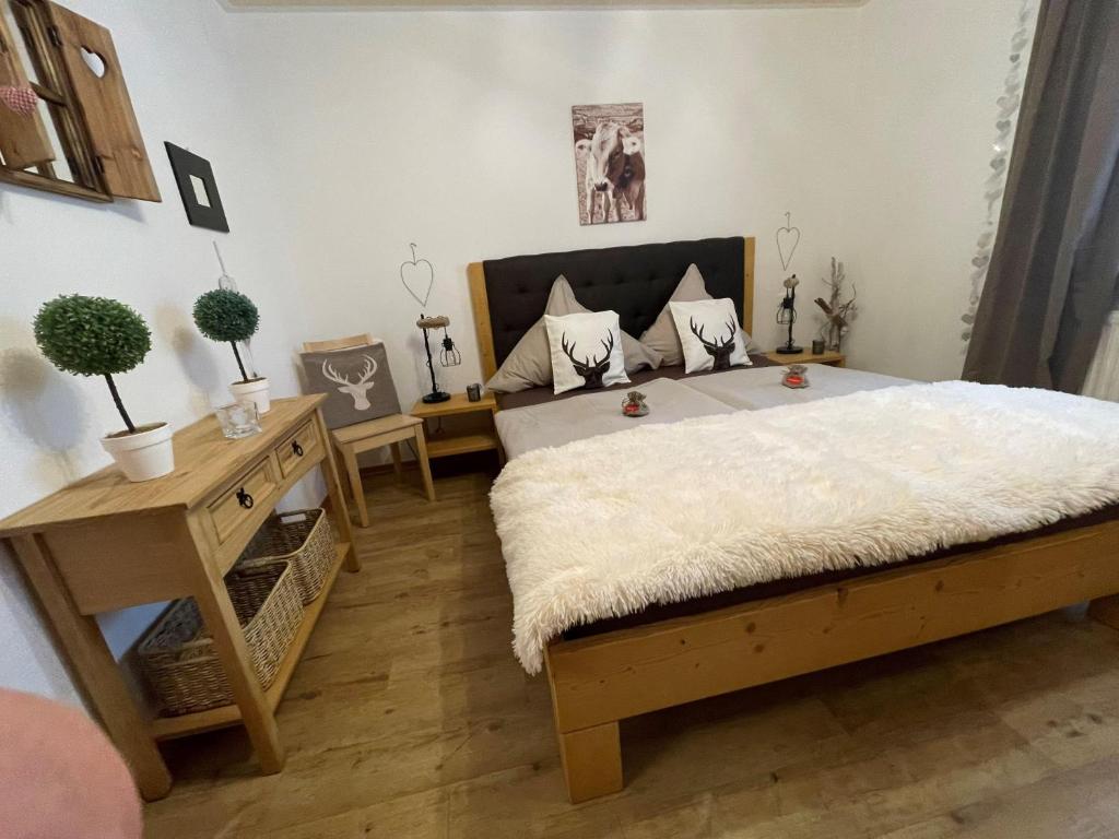 1 dormitorio con cama y mesa con macetas en Ferienwohnung Maringga, en Obermaiselstein