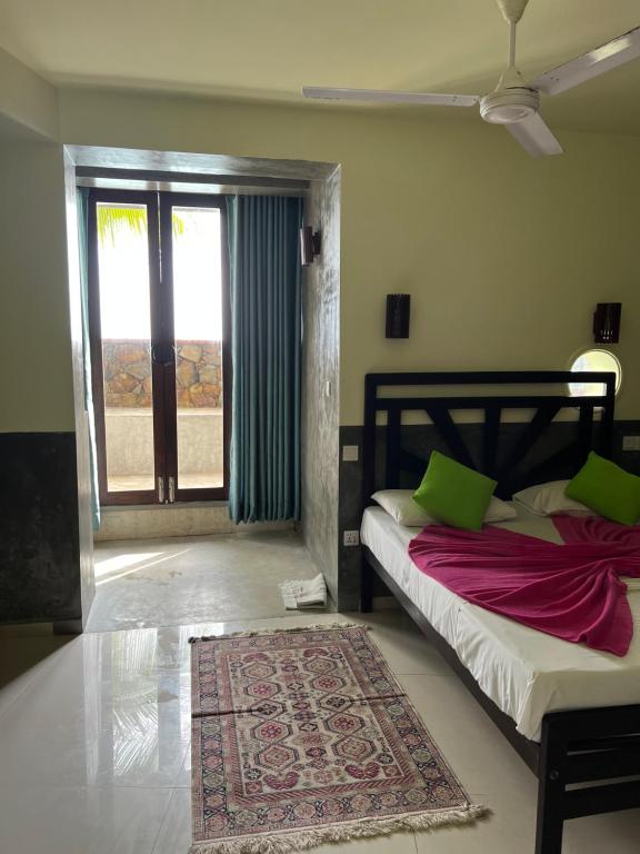 a bedroom with a bed and a window and a rug at La Veranda Di Serena in Unawatuna