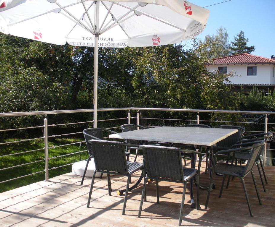 una mesa con sillas y una sombrilla en la cubierta en Easyapartments Countryside, en Salzburgo