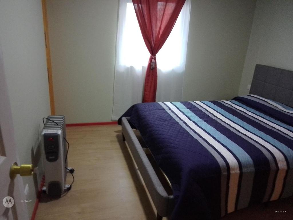 een slaapkamer met een bed en een raam bij Apartamento en pto Montt in Puerto Montt