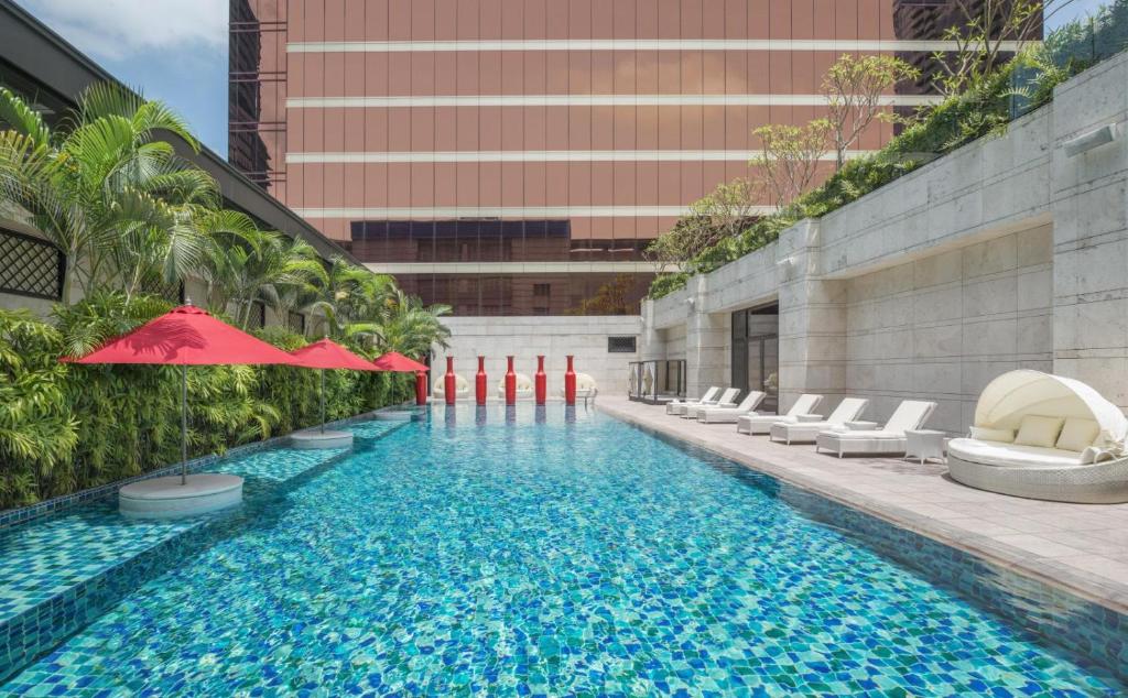 una piscina con sillas y sombrillas junto a un edificio en THE LIN Hotel, en Taichung