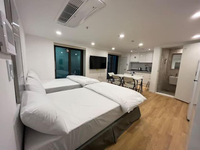 ソウルにある318 Stayの白い大きなベッドルーム(ベッド2台付)、キッチンが備わります。