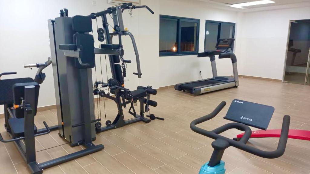 a gym with treadmills and exercise bikes in a room at Harmony Park, East Cantonments, Accra in Accra