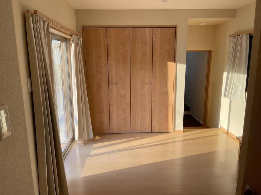 a room with a large wooden door and a room with a wooden floor at 一日一組の宿ひめ in Kushimoto