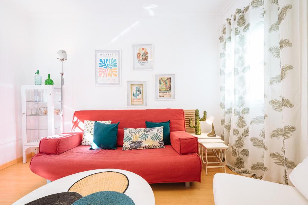 - un canapé rouge dans un petit salon dans l'établissement Precioso Apartamento San Juan de la Palma, Parking Optional, à Séville