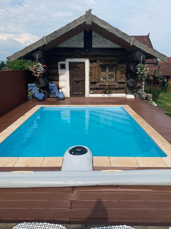 a swimming pool in front of a house at Popas Regal 