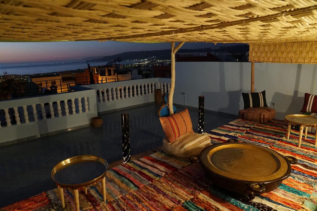a living room with a table and chairs on a balcony at Bayti surf hostel in Agadir