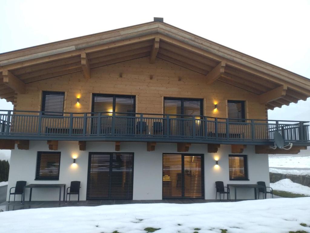 a house with a balcony on top of it in the snow at Ferienhaus Reiter Jochberg bei Kitzbühel in Jochberg