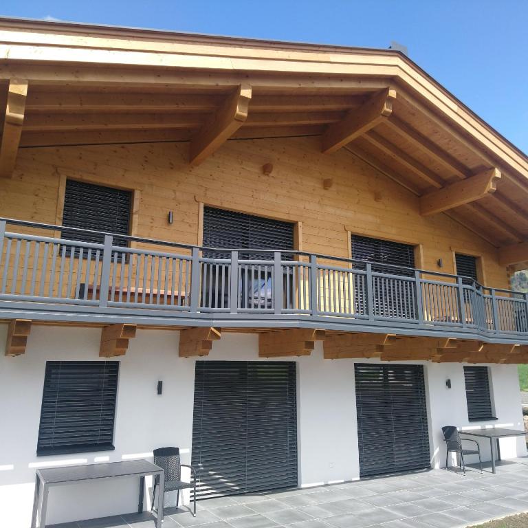 a building with a balcony and a deck at Ferienhaus Reiter Jochberg bei Kitzbühel in Jochberg