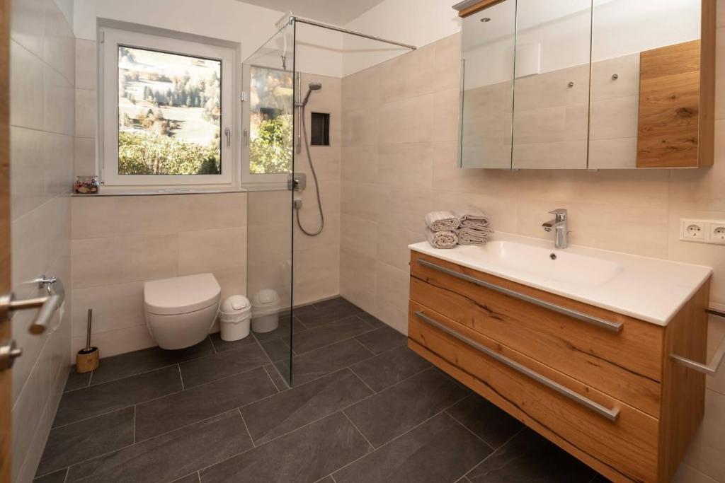 a bathroom with a sink and a shower and a toilet at Ferienhaus Reiter Jochberg bei Kitzbühel in Jochberg