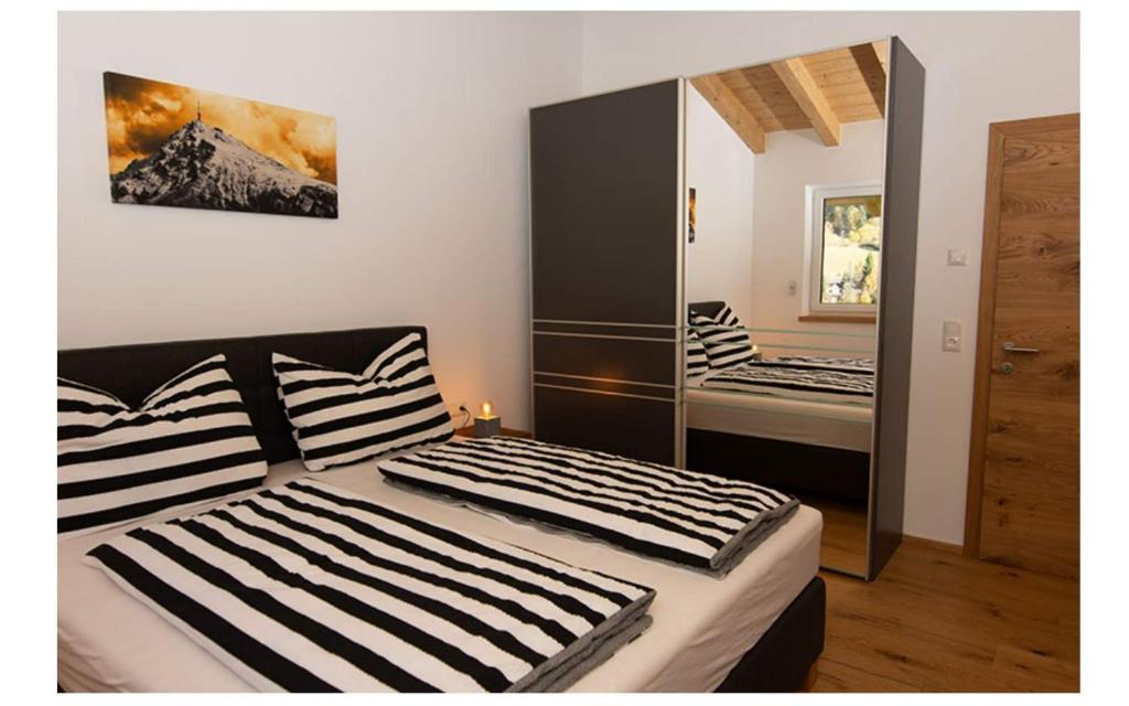 a bedroom with two beds and a mirror at Ferienhaus Reiter Jochberg bei Kitzbühel in Jochberg