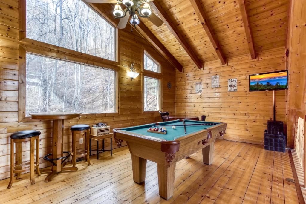 a room with a pool table in a log cabin at Papa's Bear Nest in Sevierville
