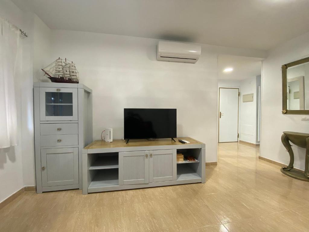 a living room with a tv on a entertainment center at TORREMOLINOS CENTRO - Beautiful , newly renovated 2 bedroom apartment in Torremolinos