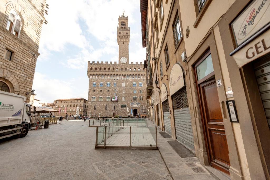 un gran edificio con una torre de reloj en una ciudad en Piazza Signoria View, en Florencia