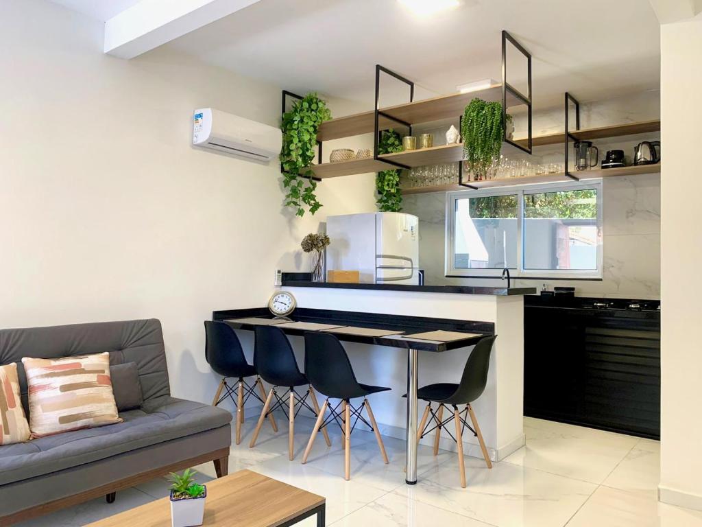 cocina y sala de estar con sofá y mesa en Sensacional duplex novo na praia dos Ingleses, en Florianópolis