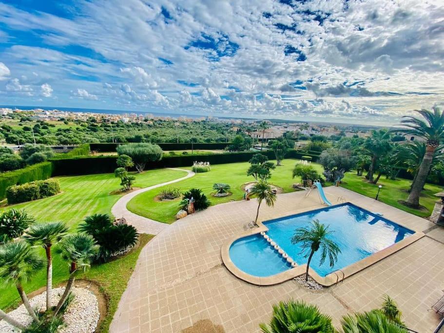 uma vista sobre uma piscina num parque com palmeiras em Finca Na Penyal em Cala Bona