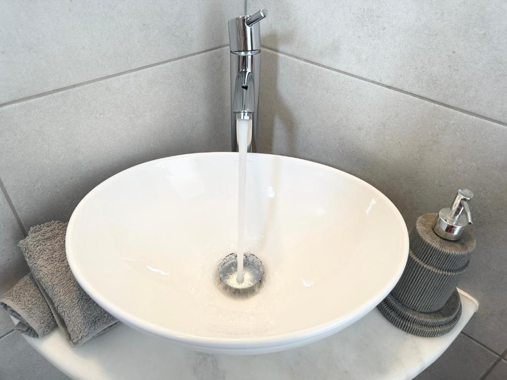 a white sink with a faucet in a bathroom at La Main Street suite in Andiparos