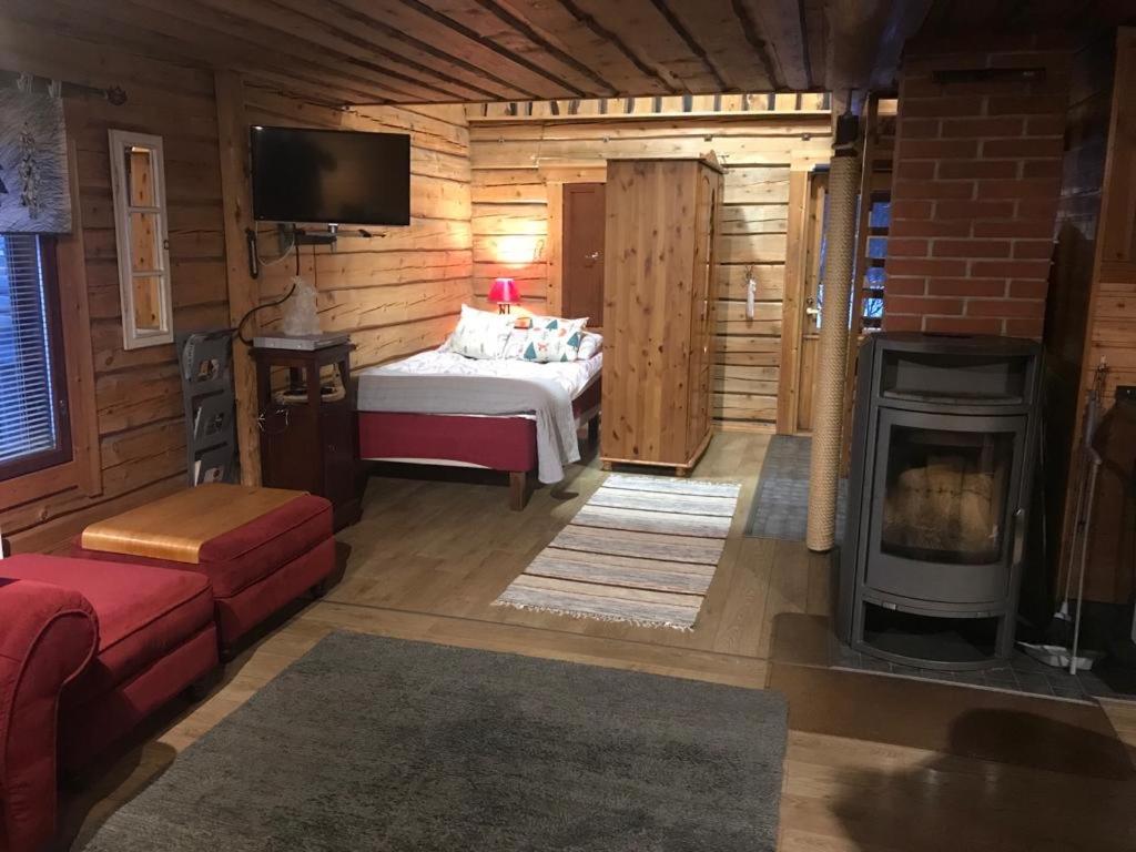 ein Schlafzimmer mit einem Bett und einem Kamin in einem Zimmer in der Unterkunft Sampo Chalet with Hot Tub in Ranua