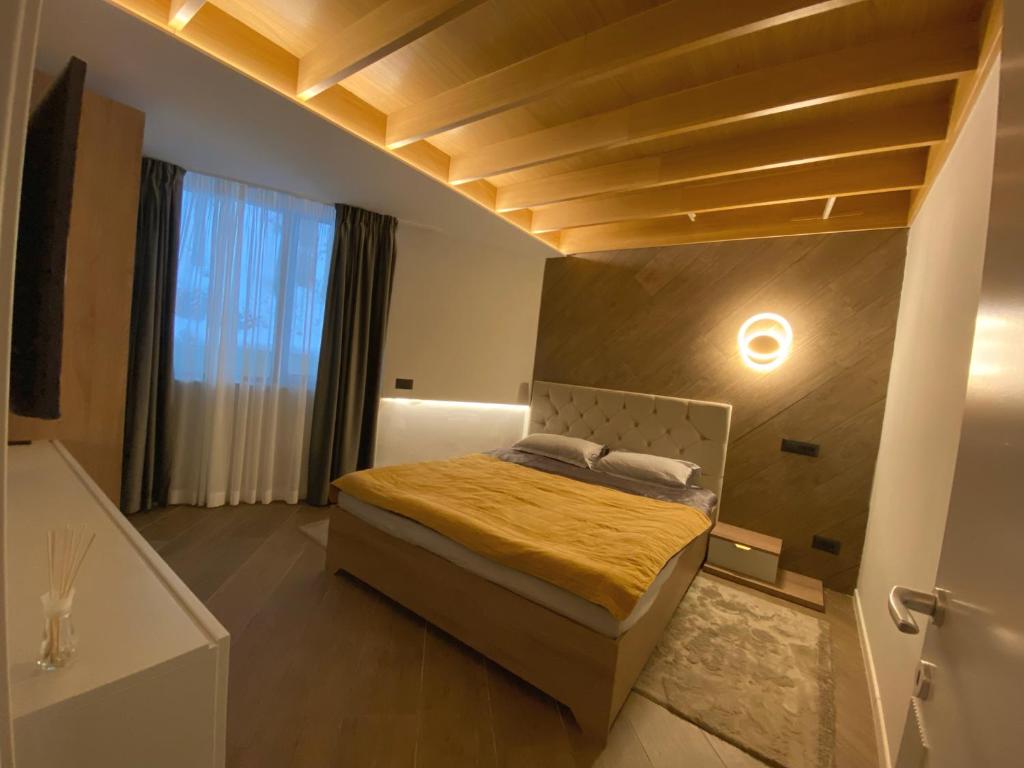 a bedroom with a bed and a large window at Teleferic9 in Predeal