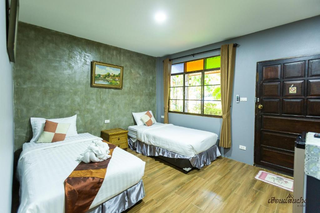 Postel nebo postele na pokoji v ubytování Huen San Fang hotel โรงแรมเฮือนแสนฝาง