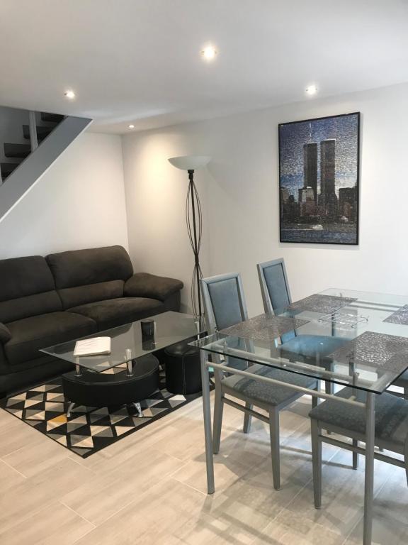 a living room with a glass table and a couch at Maisonnette cosy à Châtillon-Coligny in Châtillon-Coligny