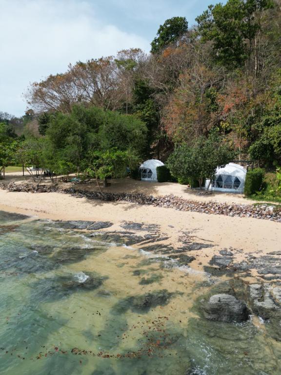 ヤオノイ島にあるTouch Glamping Koh Yao Noi ทัช แกรมปิ้ง เกาะยาวน้อยの白いドームが二つ背景にある海岸