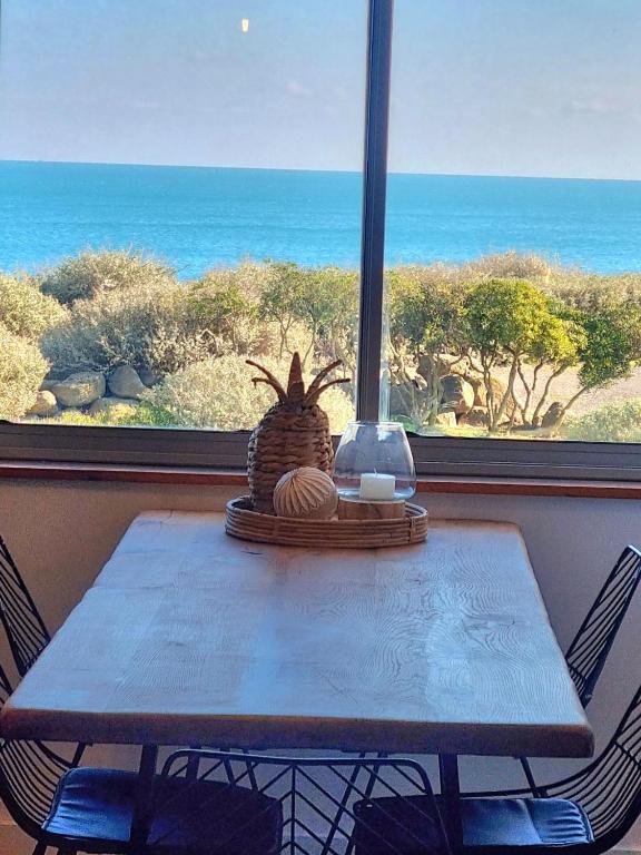 - une table avec vue sur l'océan depuis une fenêtre dans l'établissement Agde : Appartement 2 chambres au bord des falaises, au Cap d'Agde