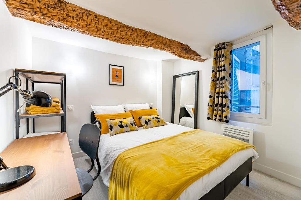a bedroom with a bed with yellow sheets and a desk at ROCHE : 3 Chambres,6 personnes, bien équipé, déco+ in Toulon