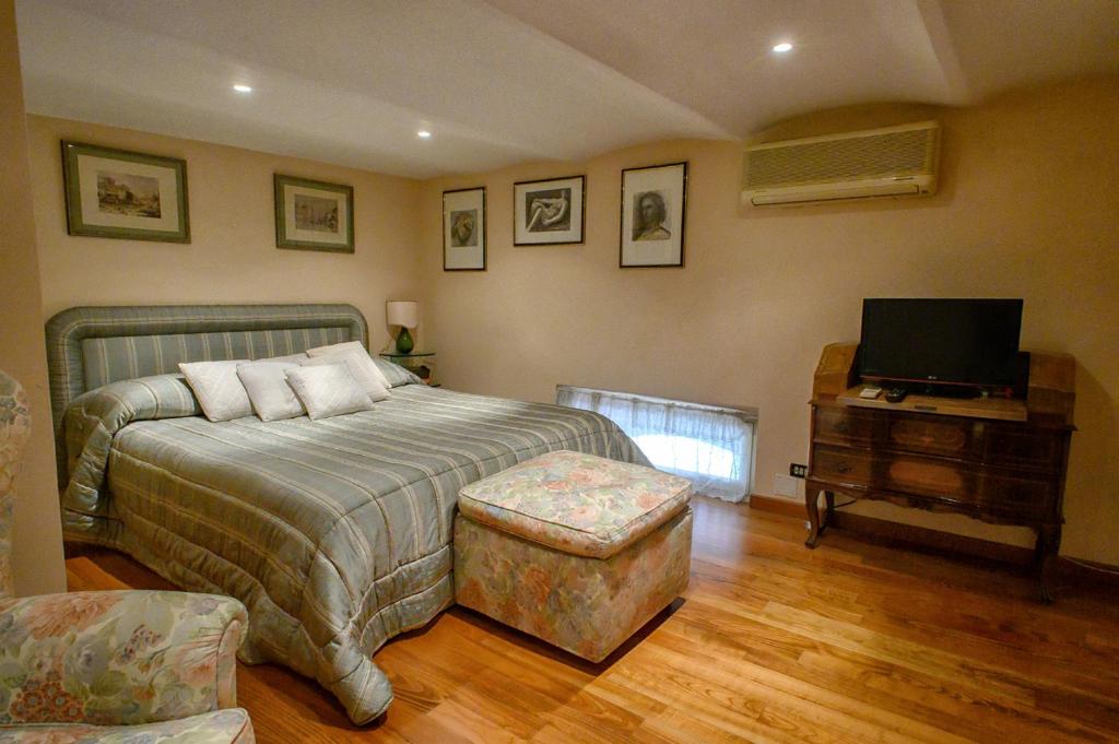 sypialnia z łóżkiem, telewizorem i krzesłem w obiekcie Apartment Roma Deluxe w Rzymie