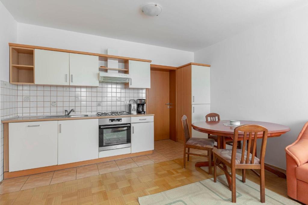 una cucina con tavolo e una sala da pranzo di Apartma Ana a Preserje