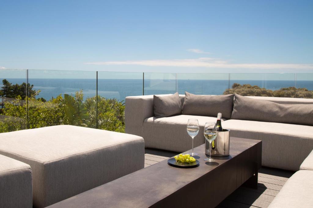 sala de estar con sofá y mesa con copas de vino en PREMIUM CAPE Camps Bay Lodge en Ciudad del Cabo