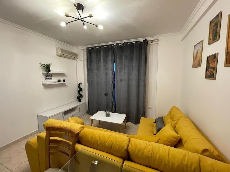 - un salon avec un canapé jaune et une table dans l'établissement Apartments Yellow, à Durrës